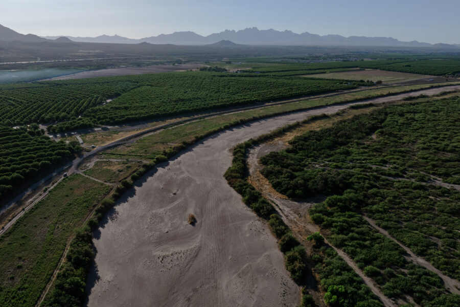 The dry riverbed of the Rio Grande is seen next to pecan orchards in Radium Springs, N.M., before annual water releases began on May 30.