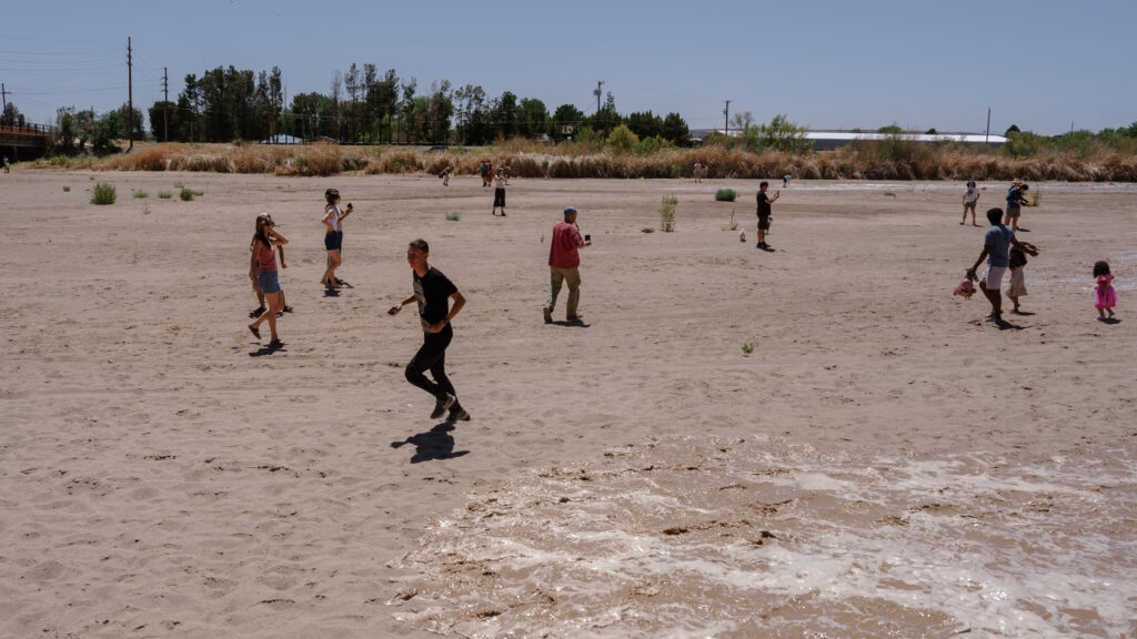 People watch as water starts flowing in the Rio Grande on May 30 in Las Cruces, N.M.