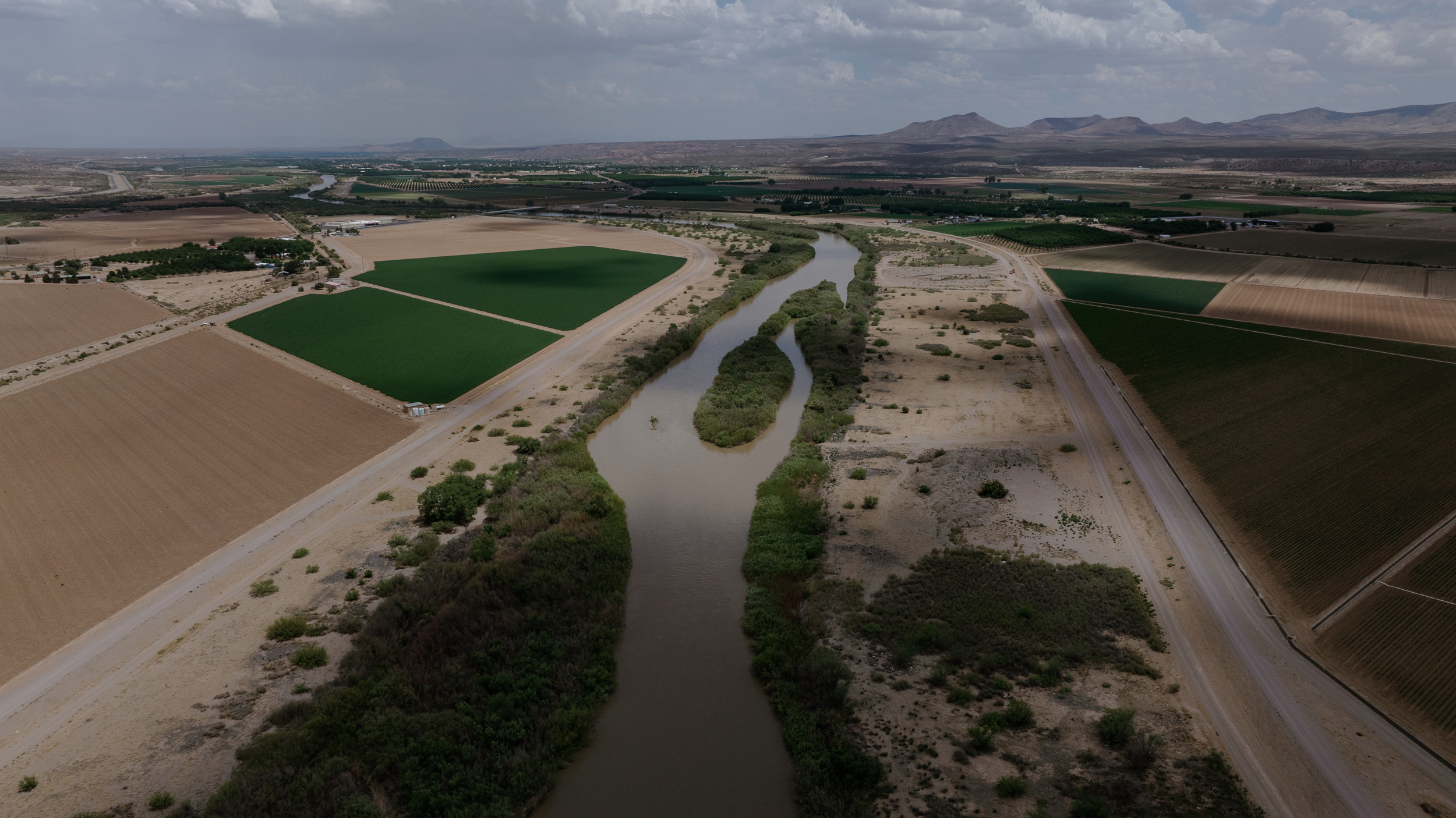 The Rio Grande flows through Hatch, N.M., on June 10. Both fallow fields and planted acreage are visible on either side of the river.