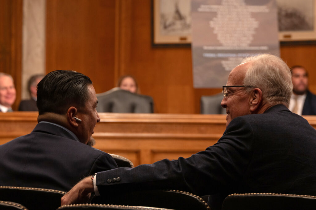 Frank White Clay (left) talks with Sen. Jerry Moran (R-Kan.), who voted in favor of the Crow Revenue Act in the Senate’s Indian Affairs Committee. Credit: Gabriel Matias Castilho/Inside Climate News