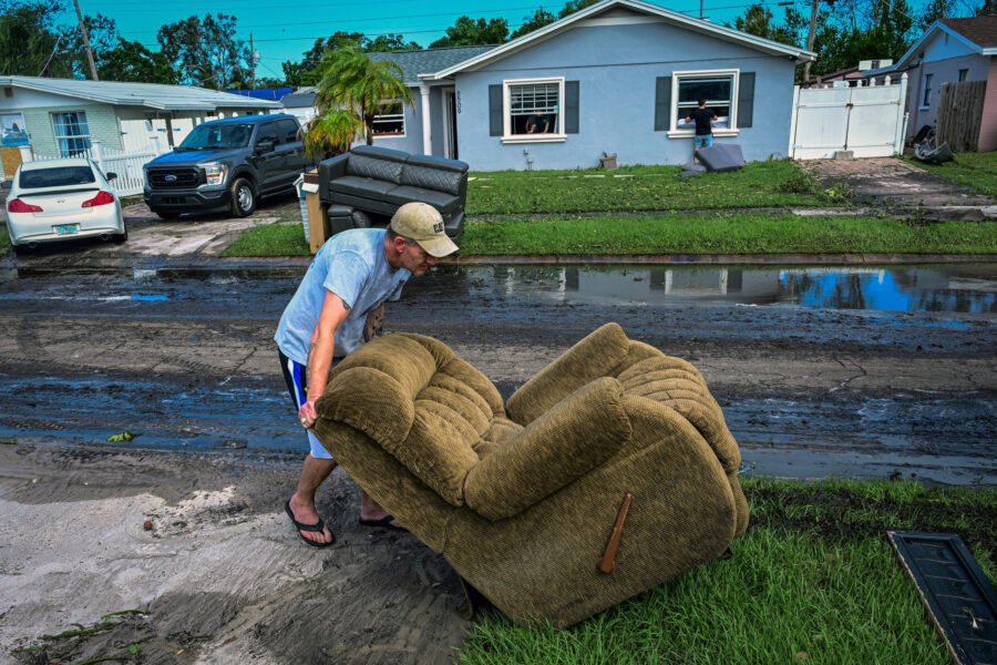 A man moves a chair in Tampa, Fla., as people remove debris and clean their homes after flooding caused by Hurricane Milton on Oct. 11, 2024. Credit: Giorgio Viera/AFP via Getty Images