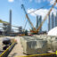 Offshore wind materials sit next to idle construction equipment at the State Pier in New London, Conn., on Aug. 25, 2025. Credit: Tyler Russell/Connecticut Public via Getty Images
