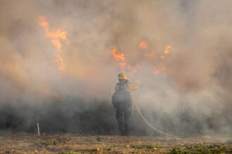 A firefighter faces a wall of flames as the Sandy Fire burns on May 19 in Simi Valley, Calif. Credit: Blake Fagan/AFP via Getty Images