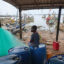 A boy sits near fishing boats in Adwoa, Ghana, on June 23. Credit: Nipah Dennis/AFP via Getty Images