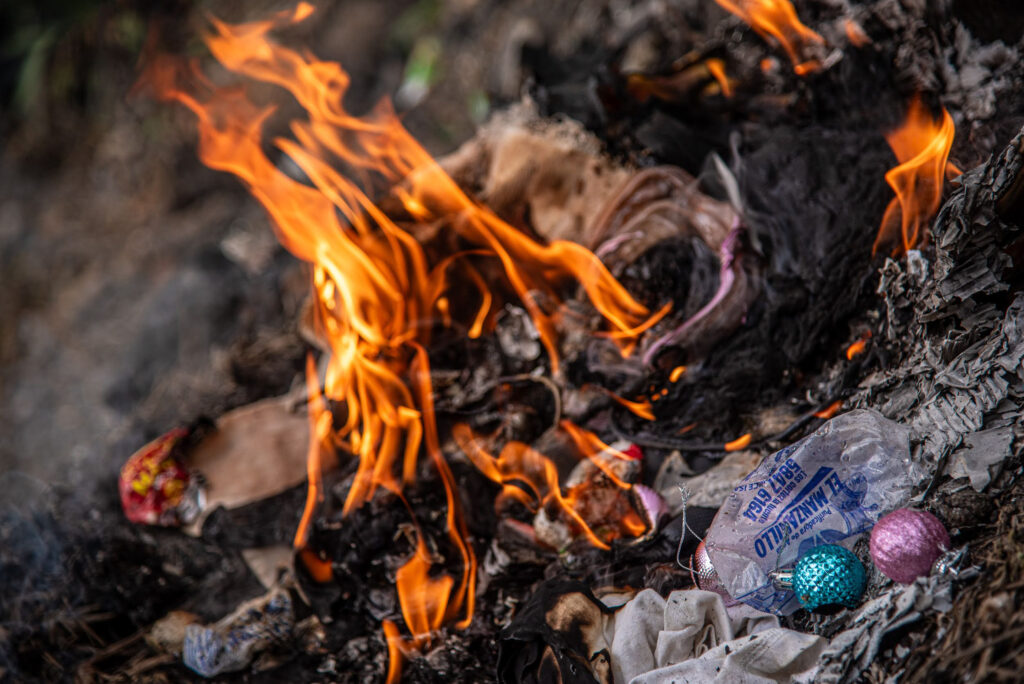 A fire to burn trash, most of it plastic, near the Ecolectivos office in La Fuente.
