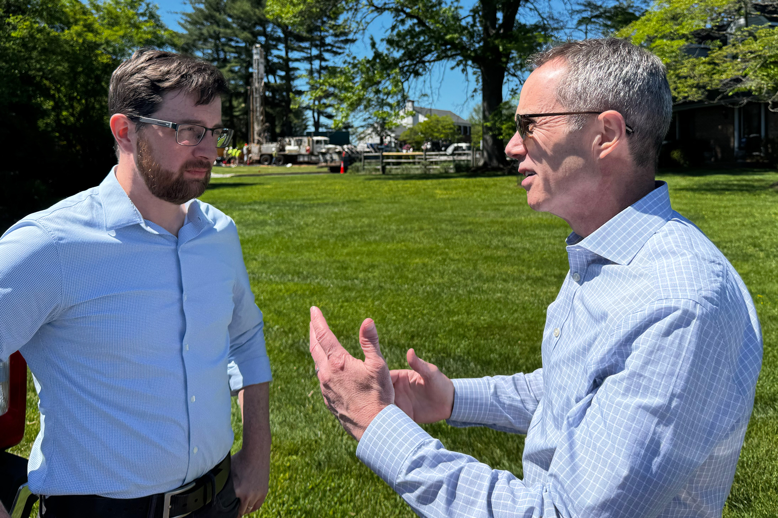Ben Weldon (left), chairman of the Upper Makefield Township board of supervisors, talks with state Sen. Steve Santarsiero in May as crews break ground on a new monitoring well. Credit: Marianne Lavelle/Inside Climate News