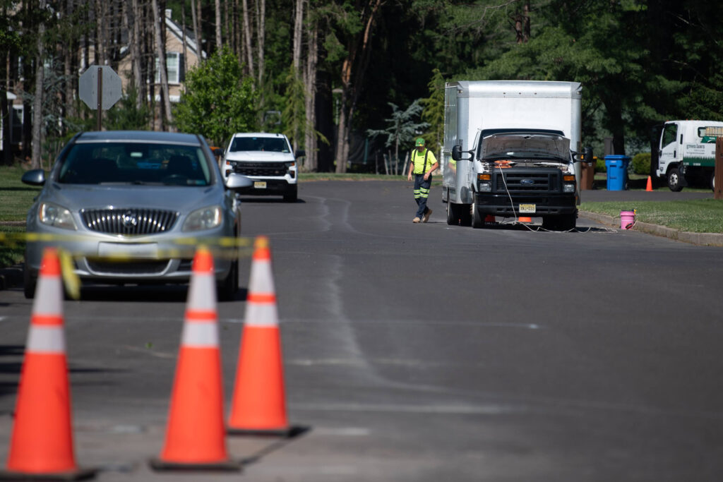 Workers install a new monitoring well along Walker Road in the Mt Eyre Manor neighborhood on June 9. Credit: Tracie Van Auken/Inside Climate News