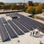 A worker explains the features of a commercial rooftop solar project that was installed by GAI Energy of Flora, Ind. Credit: GAI Energy