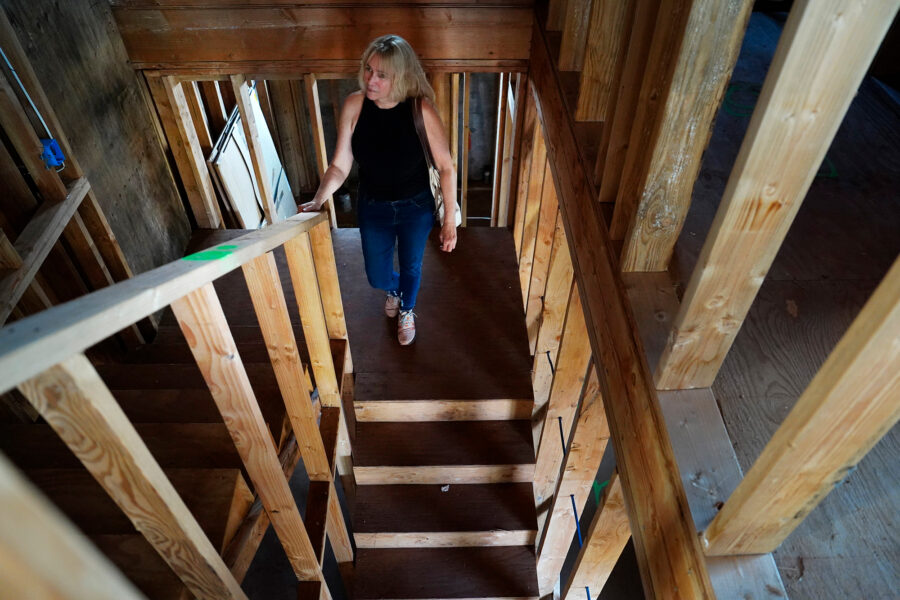 Krista Woodward walks through her stalled home reconstruction on July 1 in Lahaina. Credit: Kevin Fujii/Civil Beat