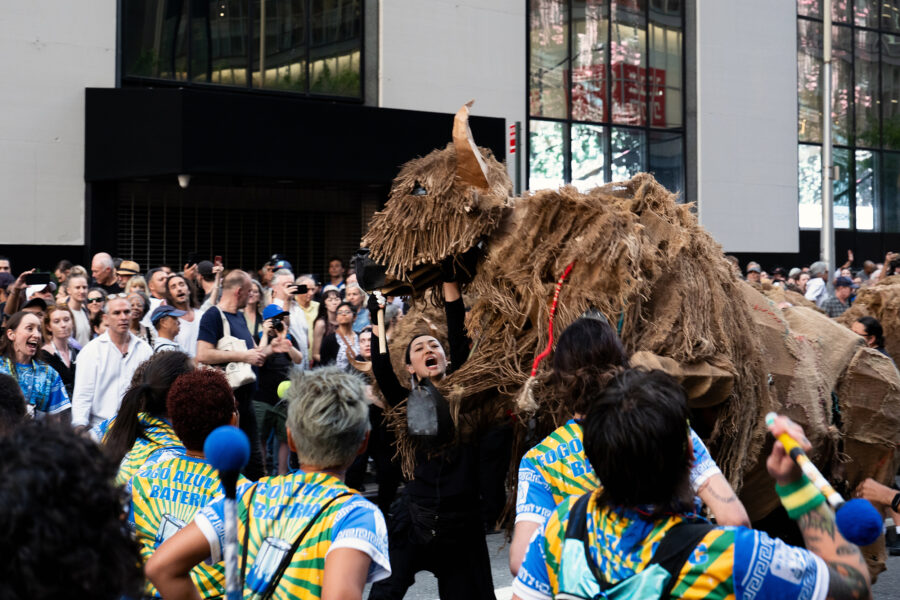 Puppeteers and their buffalo encounter a marching band near City Hall in downtown Manhattan on Saturday. Credit: Jake Bolster/Inside Climate News
