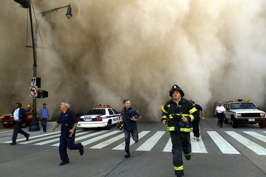 Police and firefighters run away from a toxic dust cloud caused by the World Trade Center’s Tower One collapse in New York City on Sept. 11, 2001. Credit: Jose Jimenez/Primera Hora/Getty Images