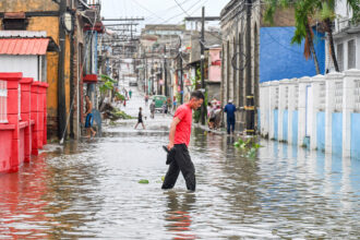 People walk through a flooded street in a neighborhood affected by Hurricane Melissa in Santiago de Cuba on Oct. 29, 2025. Credit: Yamil Lage/AFP via Getty Images