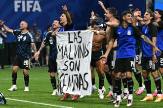 Argentina’s national team players hold a banner reading “The Malvinas are Argentine” after winning a World Cup semifinal match against England in Atlanta on July 15. Credit: Paul Ellis/AFP via Getty Images