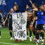 Argentina’s national team players hold a banner reading “The Malvinas are Argentine” after winning a World Cup semifinal match against England in Atlanta on July 15. Credit: Paul Ellis/AFP via Getty Images