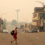 A pedestrian walks in downtown Ely, Minn., as the air is filled with smoke from multiple wildfires burning in the Boundary Waters Canoe Area Wilderness on July 15. Credit: Anthony Soufflé/The Minnesota Star Tribune via Getty Images