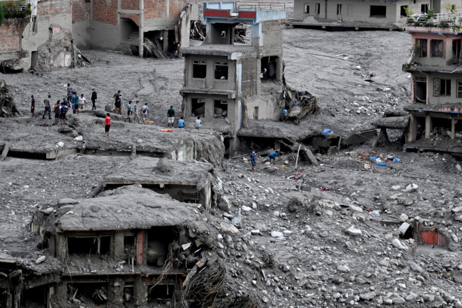 People search through debris in the aftermath of flash flooding at Trishuli Center in Nepal’s Nuwakot district on Sept. 1. Credit: Arun Sankar/AFP via Getty Images