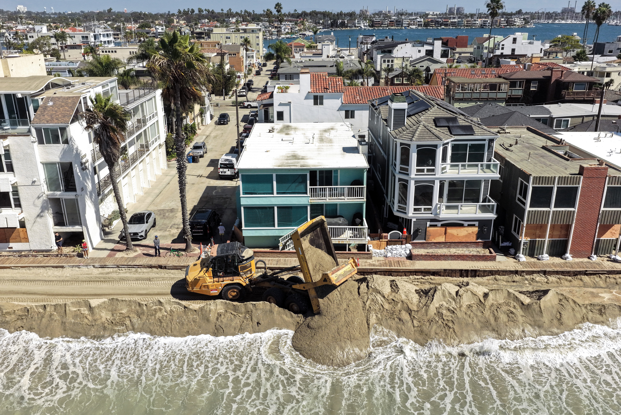 Crews unload sand to protect beachfront homes from coastal flooding along a boardwalk damaged during Hurricane Marie earlier this month in Long Beach, Calif. Credit: Mario Tama/Getty Images