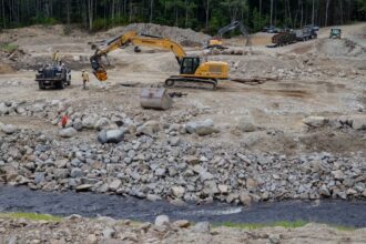 A construction crew from Sargent Corporation and engineers from Inter-Fluve work on the “nature-like fishway” that’s replacing a former ice-control dam on the Narraguagus River in Cherryfield. Credit: Katherine Emery/The Maine Monitor