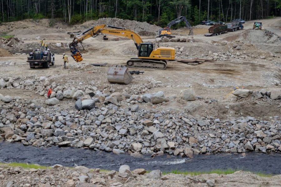 A construction crew from Sargent Corporation and engineers from Inter-Fluve work on the “nature-like fishway” that’s replacing a former ice-control dam on the Narraguagus River in Cherryfield. Credit: Katherine Emery/The Maine Monitor