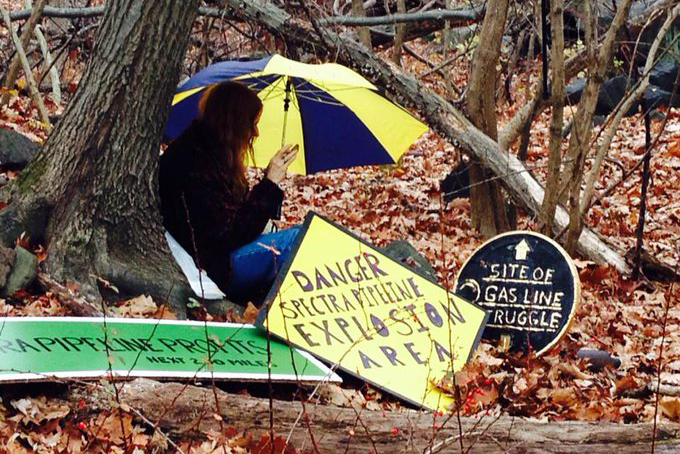 Nancy Vann sits beside a tree on her property to prevent it from being cleared for the construction of a pipeline. Credit: Courtesy of Nancy Vann