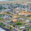 An aerial photo shows a portion of Lahaina, Hawaii, near the water. Properties are a mix of homes, houses under construction and empty lots.