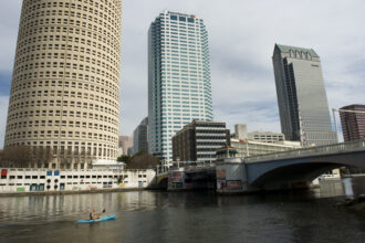A canoer passes along the Hillsborough River among the office buildings downtown in Tampa, Florida, on Jan. 22, 2012. Credit: Linda Davidson/The Washington Post via Getty Images