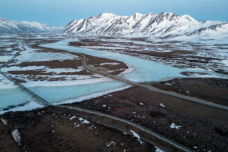 An aerial view of the Dalton Highway and a portion of the Trans-Alaska Pipeline System crossing over the frozen Atigun River in North Slope Borough, Alaska. Credit: Lance King/Getty Images