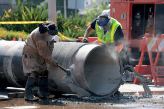 Crews prepare a replacement pipe as they repair a water main in West Hollywood, Calif., on July 17. Credit: Myung J. Chun/Los Angeles Times via Getty Images