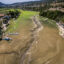 Boats are left stranded on a dried-up river on the border of France and Switzerland during a heatwave in Europe on Aug 11. Credit: Fabrice Coffrini/AFP via Getty Images