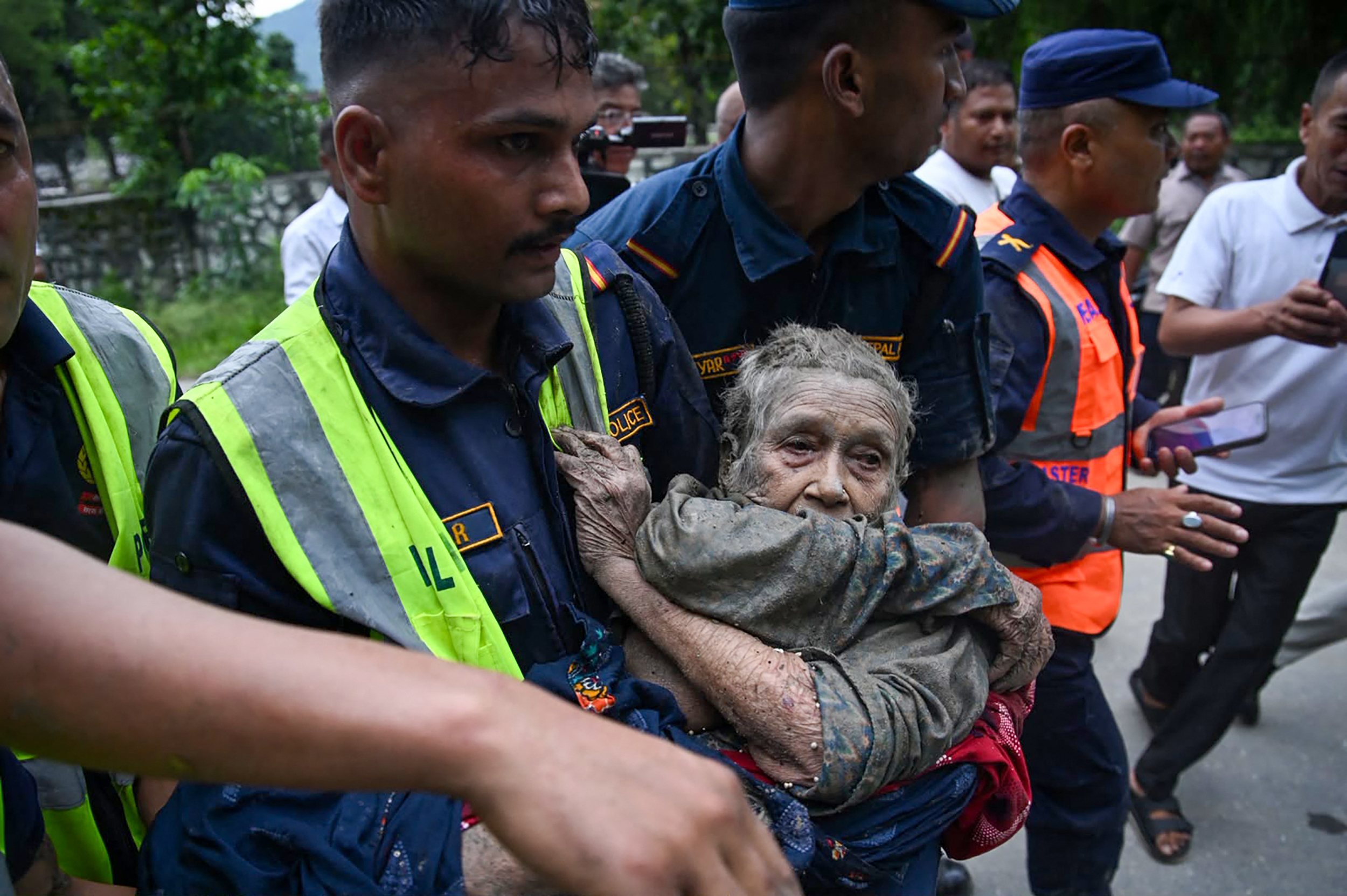 Rescue workers help a resident affected by flash floods in Nepal’s Nuwakot district on Aug 26. Credit: Prakash Mathema/AFP via Getty Images