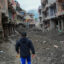 A man walks past debris from houses damaged by devastating floods in Devighat, in Nepal's Nuwakot district, on Oct. 15, 2026.