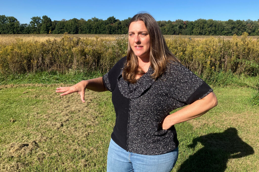 Alicia Doty stands near the edge of her property in front of the site of a proposed Amazon Web Services data center. She opposes the development, and it’s playing a role in how she thinks about voting in November. Credit: Dan Gearino/Inside Climate News