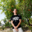 Sylvie Andrews stands under a pomegranate tree on her property devastated by the Eaton Fire in Altadena, Calif. Credit: Carlin Stiehl/Inside Climate News