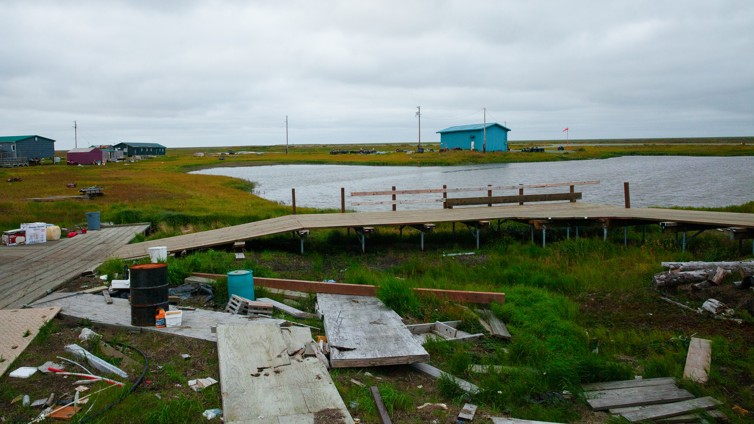 Amid the debris still on the ground in Kwigillingok, new boardwalks are reinforced with steel helical piles to make them storm proof.  Credit: Olga Loginova/Inside Climate News
