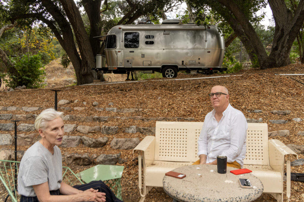 Mark Pickett and Maryrose Smyth sit on patio furniture in front of the site where their house once stood. Credit: Nina Dietz/Inside Climate News