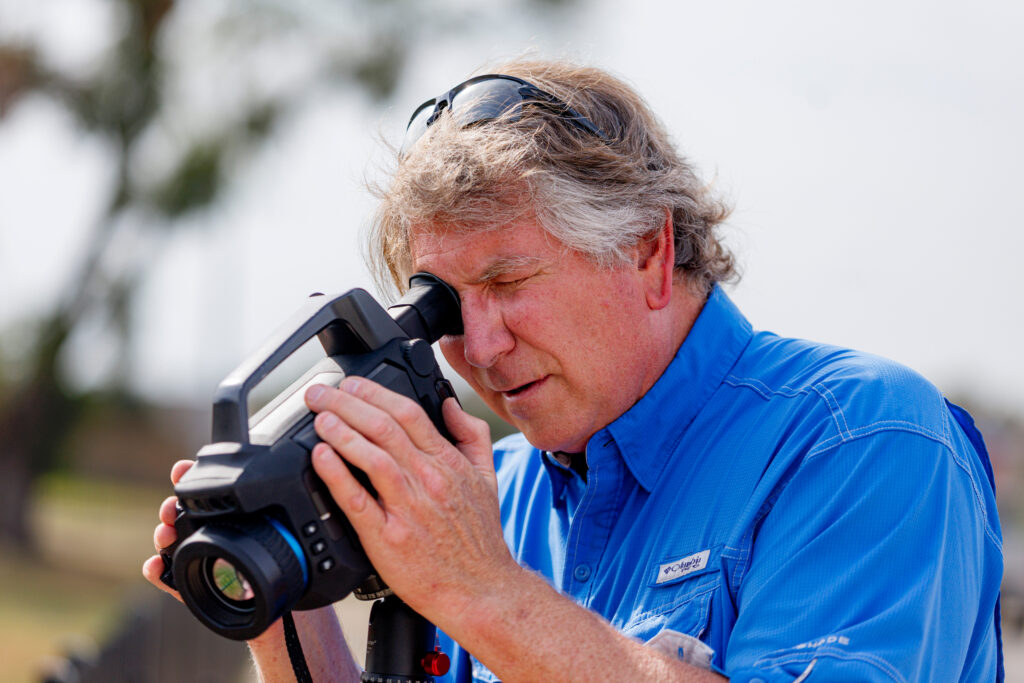 James Tim Doty uses a thermal imaging camera to record hydrocarbon emissions from the plugged Thompson Callaway Spears #1 well on Sept. 27. Credit: Sam Owens/San Antonio Express-News