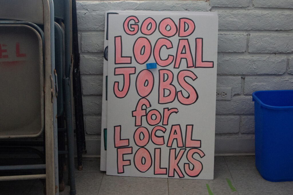 A hand-drawn sign calling for “good local jobs for local folks” rests against a wall inside The Becoming Project’s office in Calipatria, Calif. Credit: Carla Samon Ros/CJI