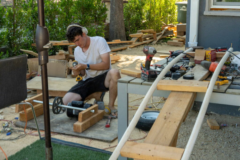 Sawyer builds a rollercoaster out of scrap materials left over from the construction site next door to his family’s rental in Altadena. Credit: Nina Dietz/Inside Climate News