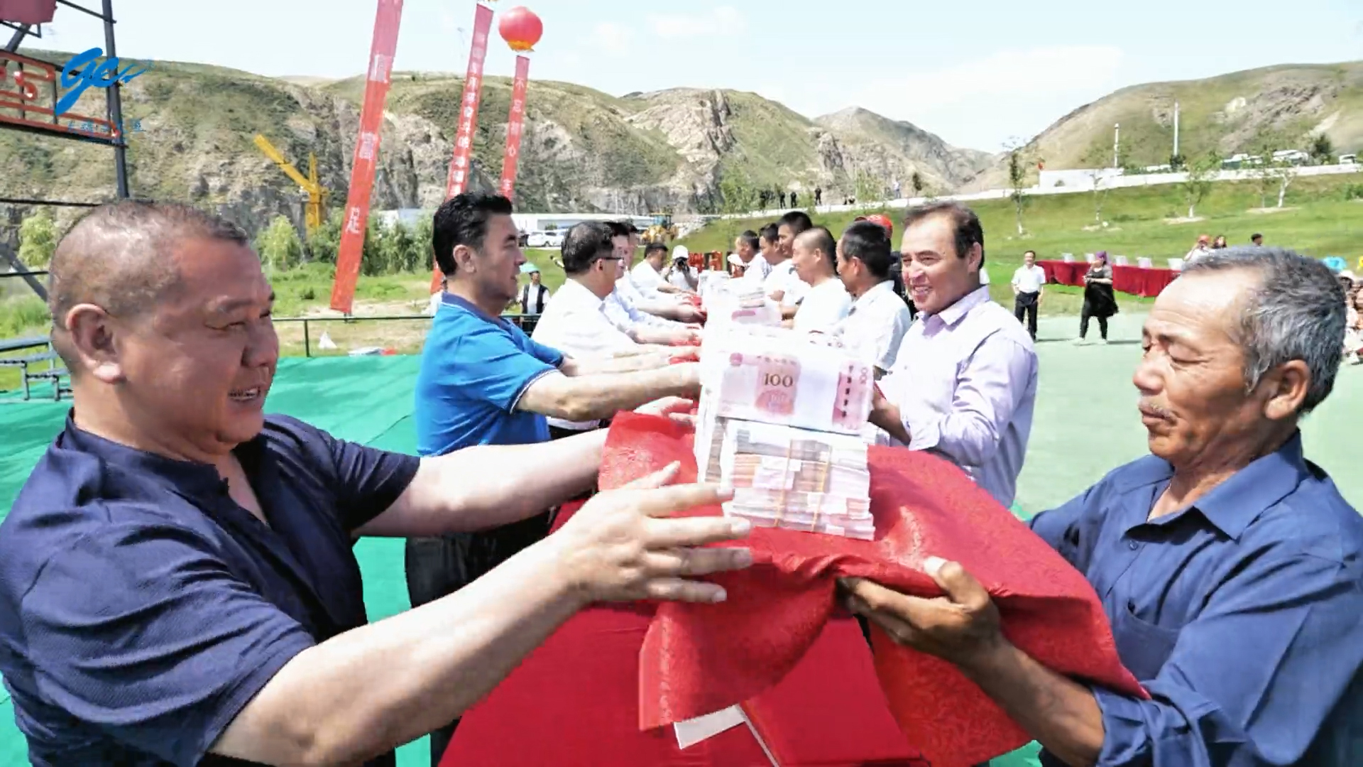 The chairman of Xinjiang Tianyun Organic Agriculture, Zhang Xiu, hands platters of cash to villagers as part of the company’s annual profit distribution ceremony, which began in 2017. Credit: Xinjiang Tianyun Organic Agriculture