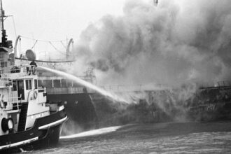 A fire rages on the SS South America, one of at least 90 fires that broke out on ships carrying fishmeal between the 1950s and 1970s. In an effort to prevent more fishmeal fires on cargo ships, the feed industry began treating fishmeal with ethoxyquin. Credit: Sepia Times, NY Daily News, Evers, Joost/Anefo